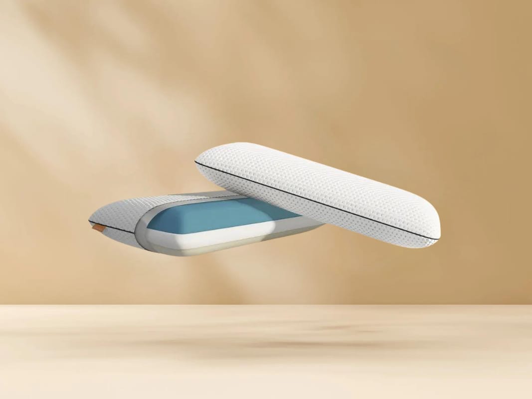 Deux coussins modernes avec une housse texturée blanche et une couche intérieure bleue flottent sur un fond beige. Un badge circulaire en français en bas à droite indique Oreiller le plus vendu Emma.